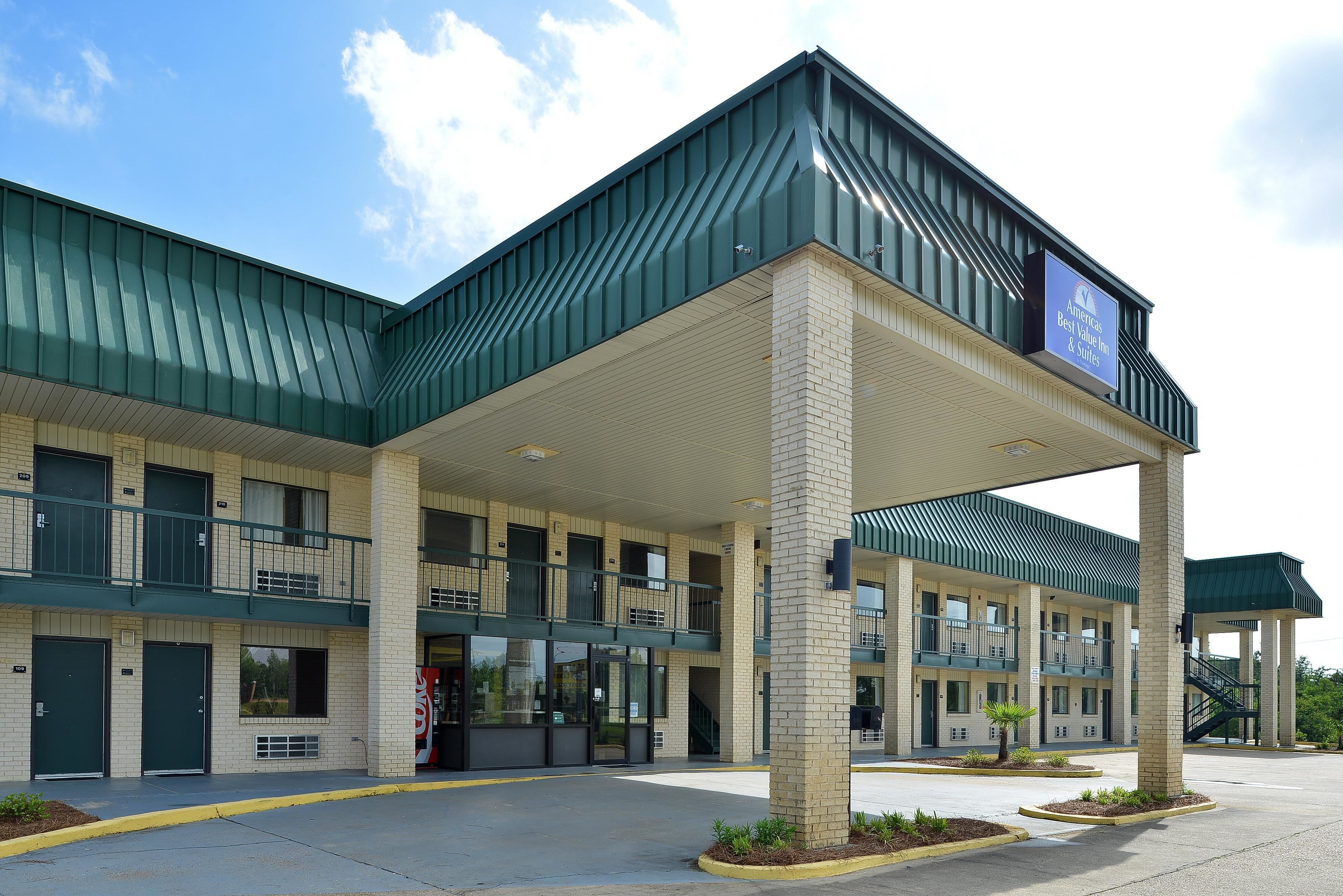 A motel with a green roof, multiple balconies, and a sign advertising 'Best Value Free & Suites'.