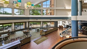 A spacious indoor area with multiple seating arrangements, large windows, and a bar area. - Turf Valley Resort (Ellicott City)