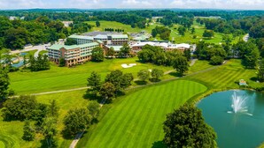 A golf course with a pond and a building complex with multiple buildings and a large lawn area. - Turf Valley Resort (Ellicott City)