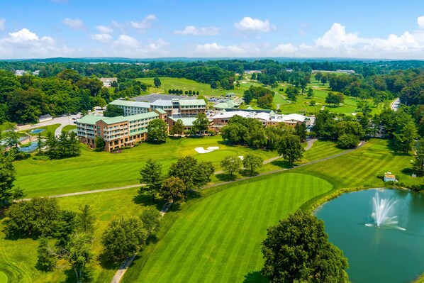 A golf course with a pond and a building complex with multiple buildings and a large lawn area. - Turf Valley Resort (Ellicott City)