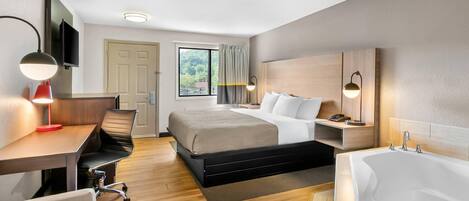 Una habitación de hotel moderna con cama, escritorio, silla y un baño independiente.