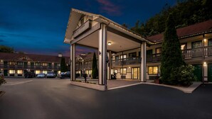 A hotel with a covered entrance, multiple balconies, and a parking lot. - Quality Inn (Helen)