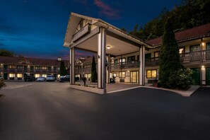 A hotel with a covered entrance, multiple balconies, and a parking lot. - Quality Inn (Helen)