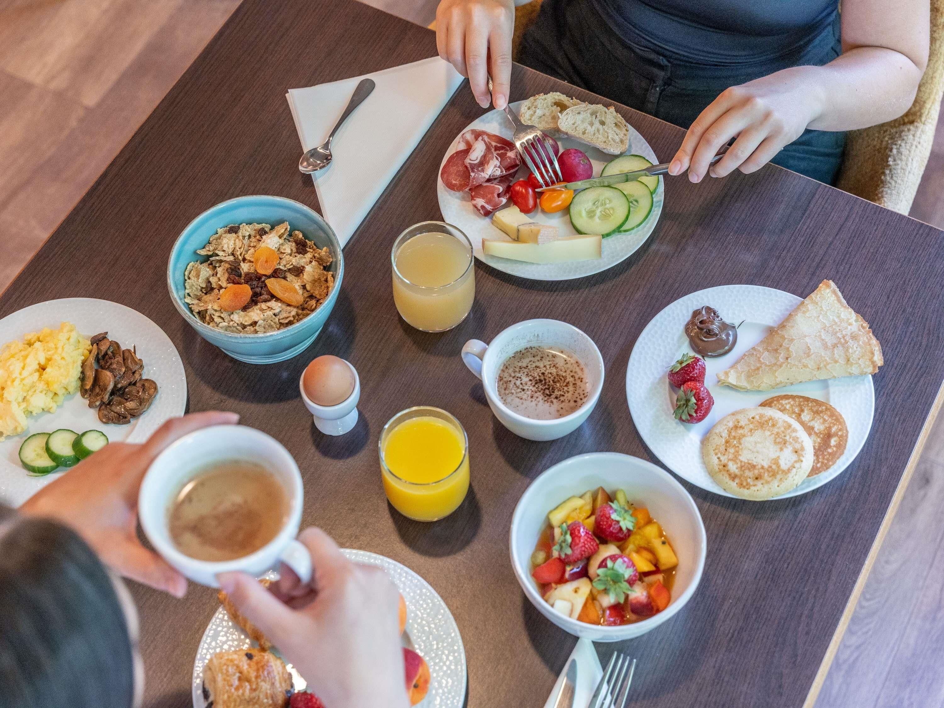 Un desayuno con diversas opciones de comida y bebidas sobre una mesa.