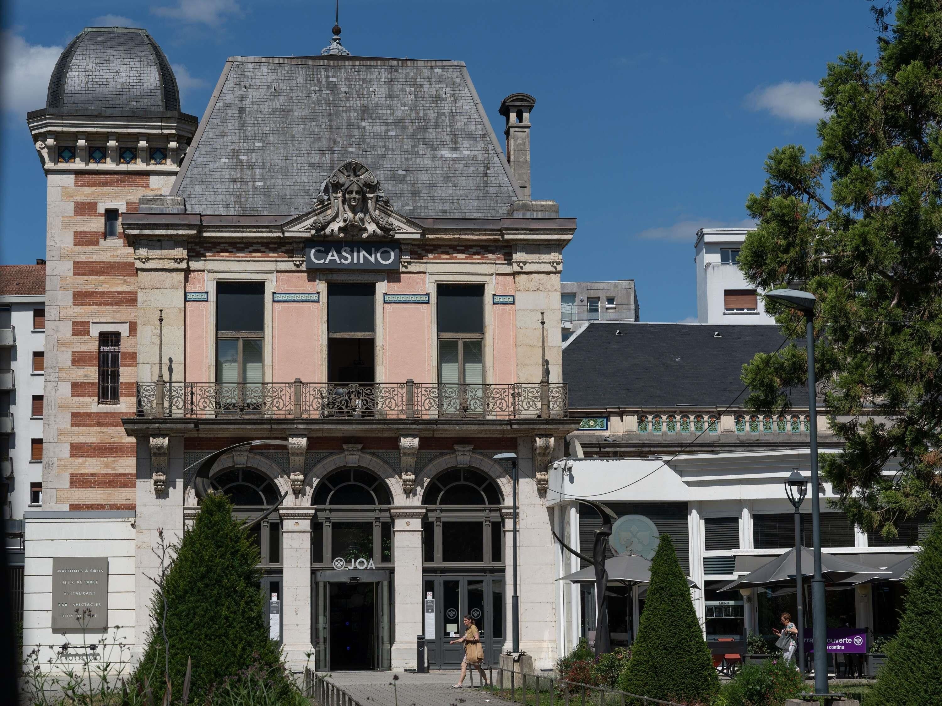 En historisk bygning med et markant kasinoskilt, buede vinduer og en balkon med dekorativt gelænder.