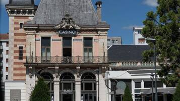 En historisk bygning med et markant kasinoskilt, buede vinduer og en balkon med dekorativt gelænder.