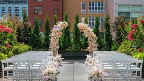 A ceremony aisle with white chairs and floral arches. - Sheraton LaGuardia East Hotel (Flushing)