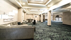A spacious hotel lobby with a large seating area, a reception desk, and a clock on the wall. - Holiday Inn Kearney by IHG (Kearney)