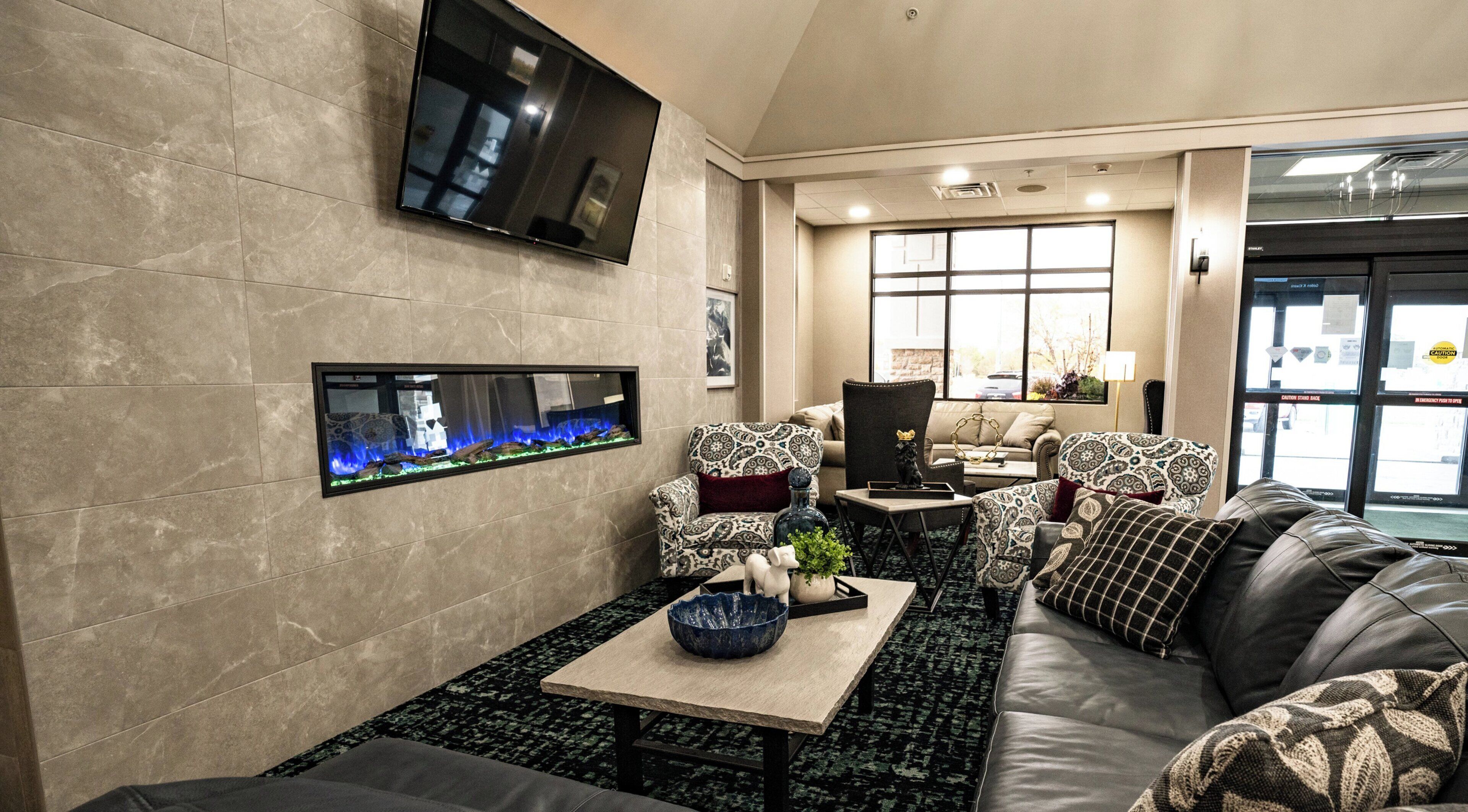 Una sala de estar moderna con una televisión de pantalla plana, chimenea, sofá y una mesa de centro.