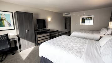 A hotel room with a bed, a desk, a television, and a wardrobe.