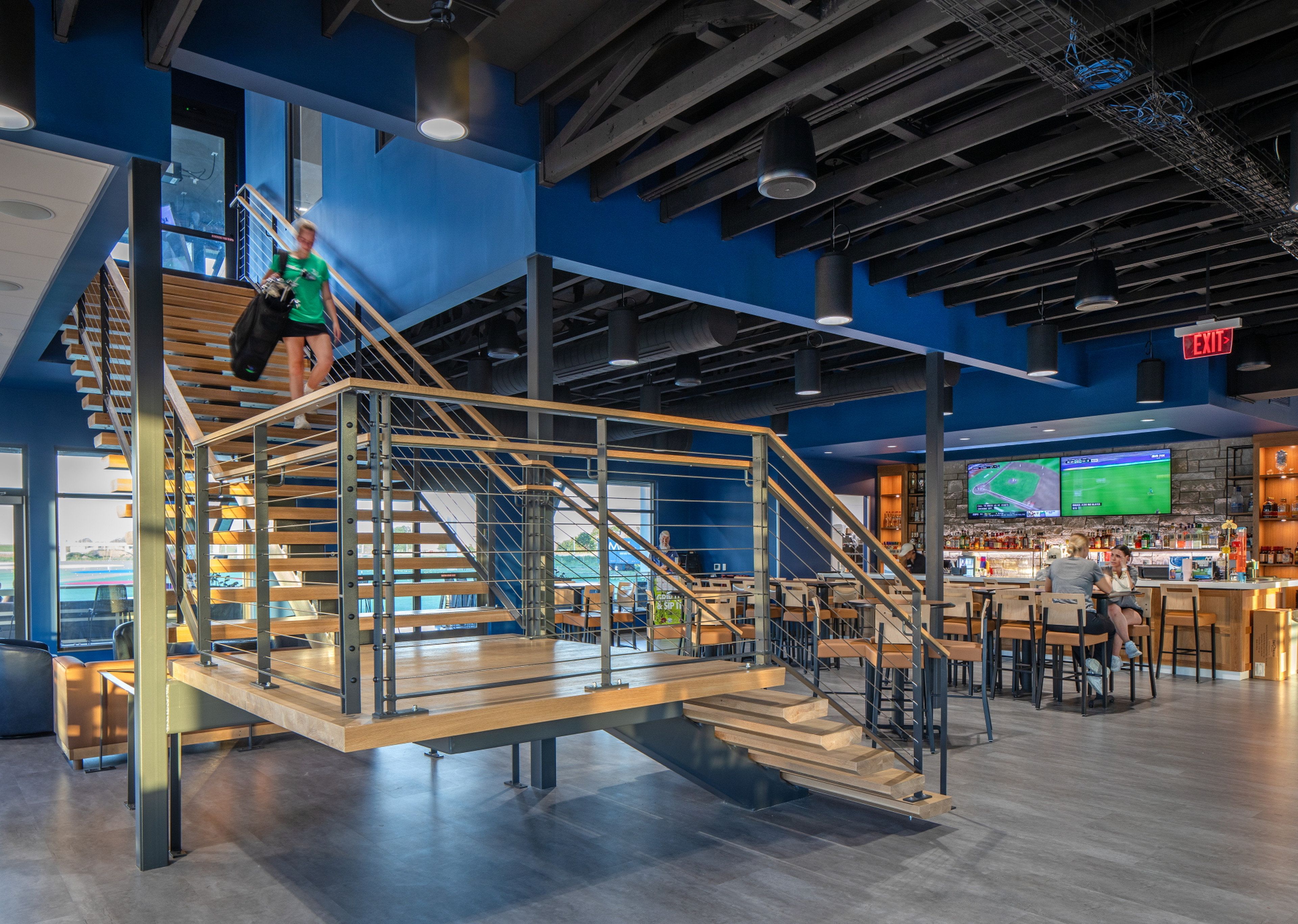 A modern interior with a staircase, seating area, and a bar.