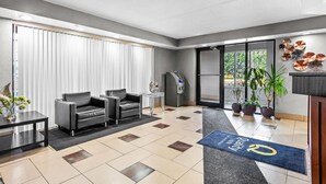 Eine moderne Hotelhalle mit Empfangsschalter, Sitzgelegenheiten und Topfpflanzen.