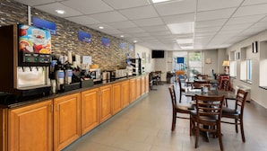 A modern restaurant with a long counter, a coffee machine, and multiple tables and chairs. - Best Western Adena Inn (Chillicothe)