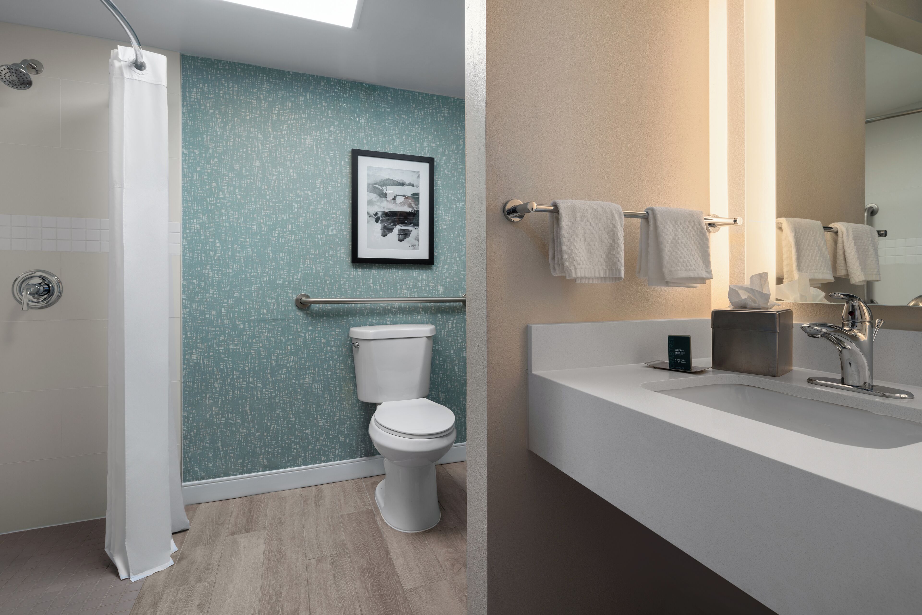 A modern bathroom with a shower, toilet, and sink.