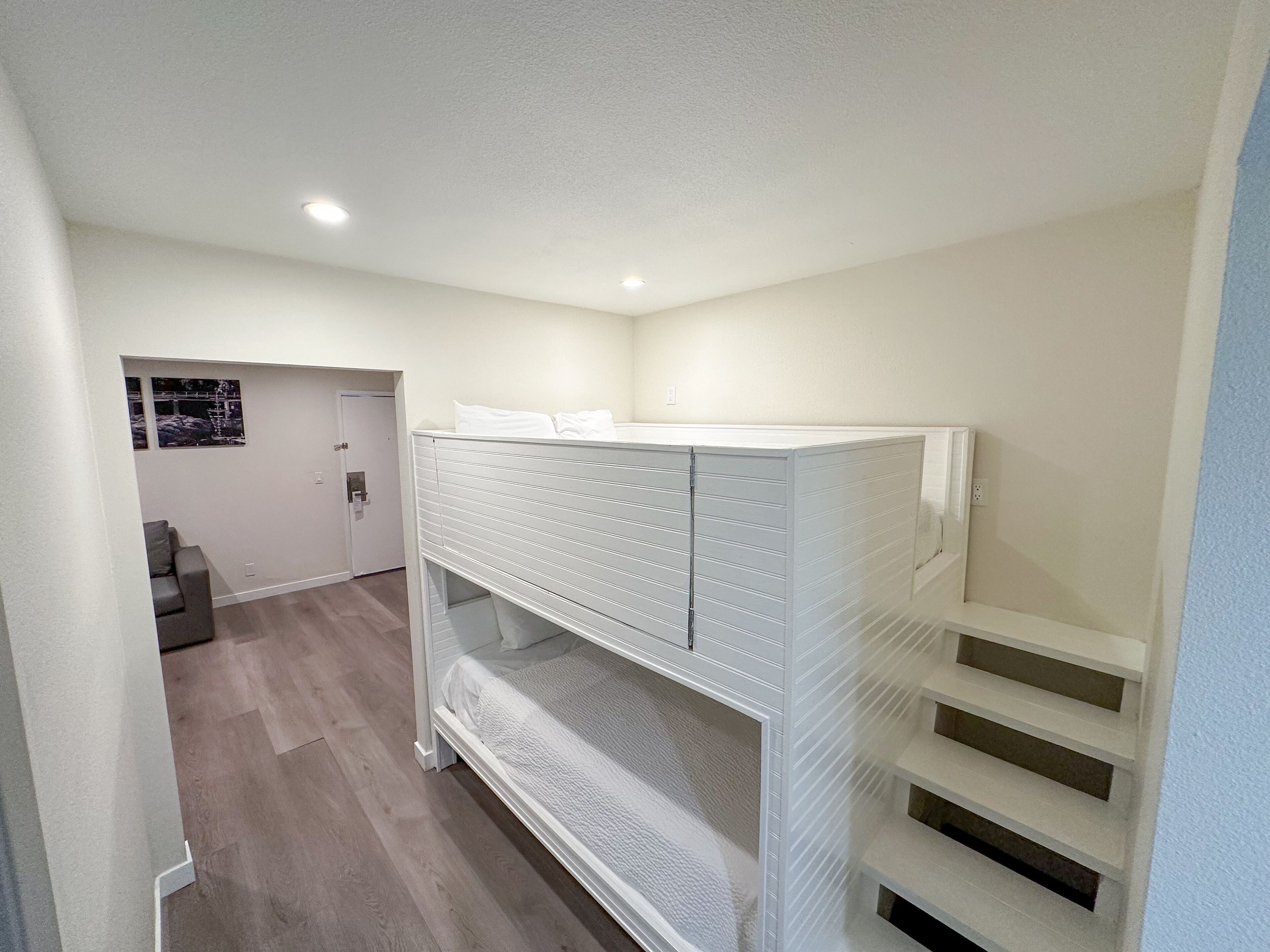 A bunk bed with a headboard, a door, and a small window.