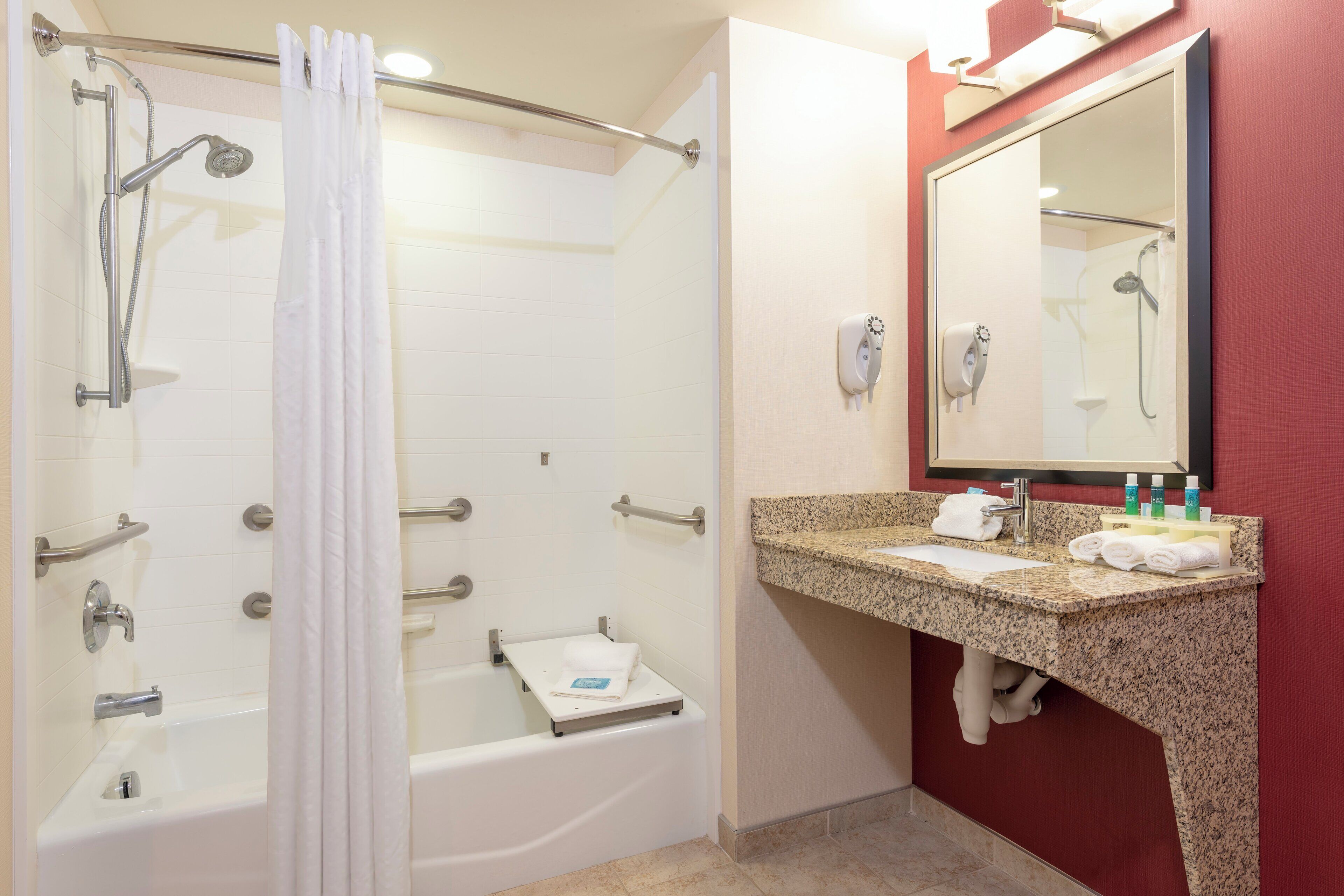 A bathroom with a shower, a bathtub, a vanity with a mirror, and a towel rack.