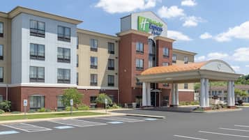 Welcome to Holiday Inn Express & Suites, featuring a modern design with a covered entrance and convenient parking.