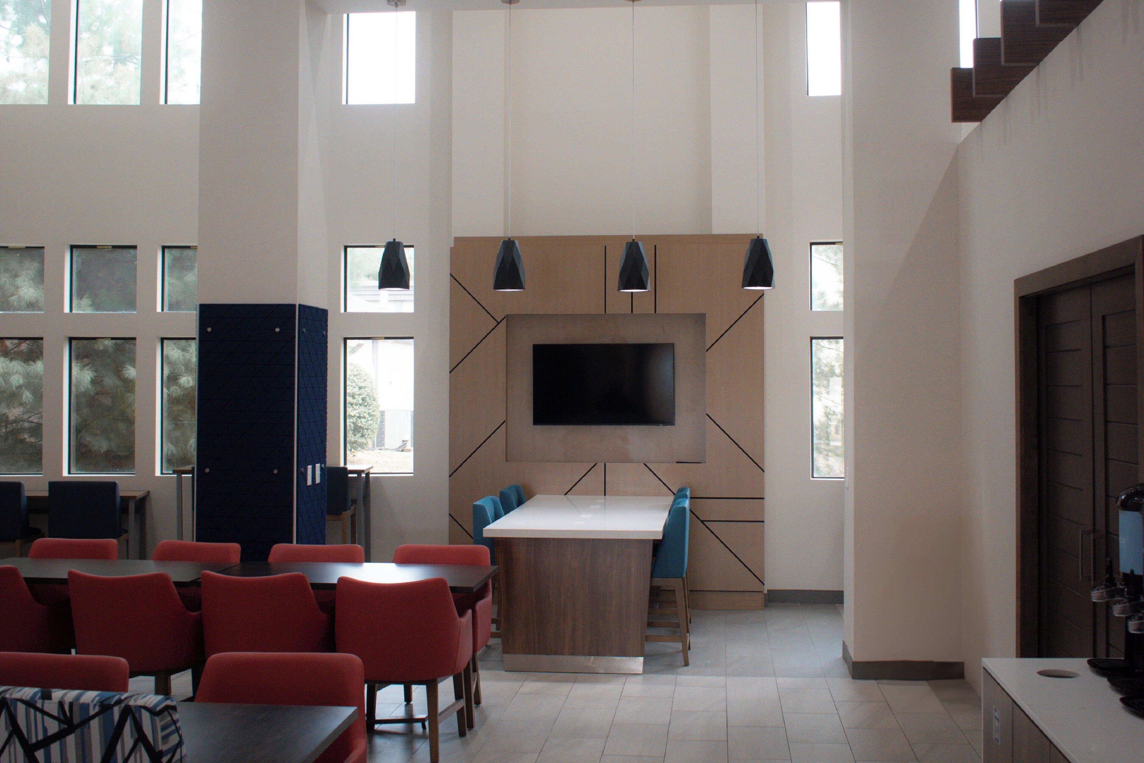 Una cocina moderna con un televisor grande, armarios de madera y una isla central.