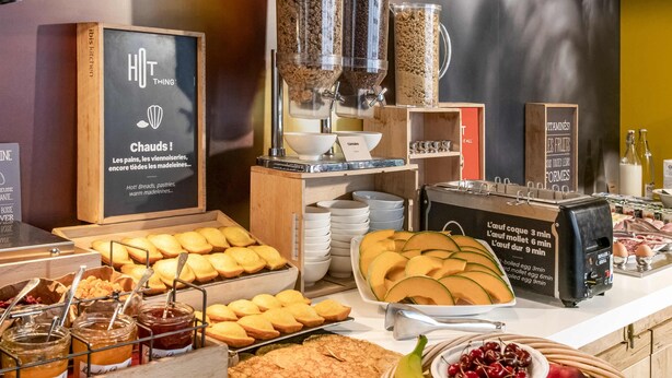 Un buffet de petit-déjeuner proposant un assortiment de pains, de viennoiseries et de fruits.