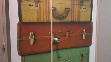 Un mur composé de valises empilées, de différentes couleurs.