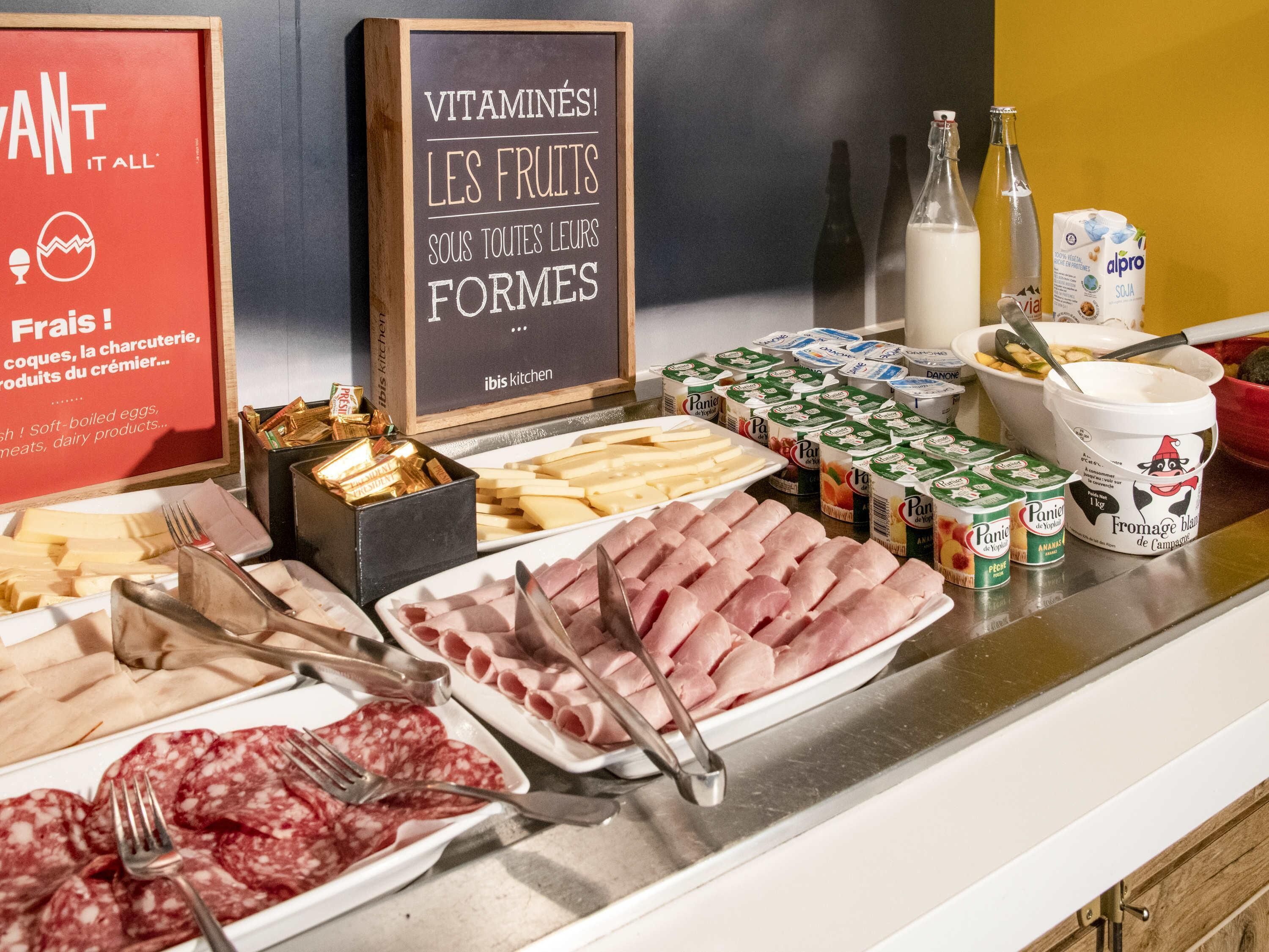 Un buffet con diversi cibi, tra cui carni, formaggi e latticini.