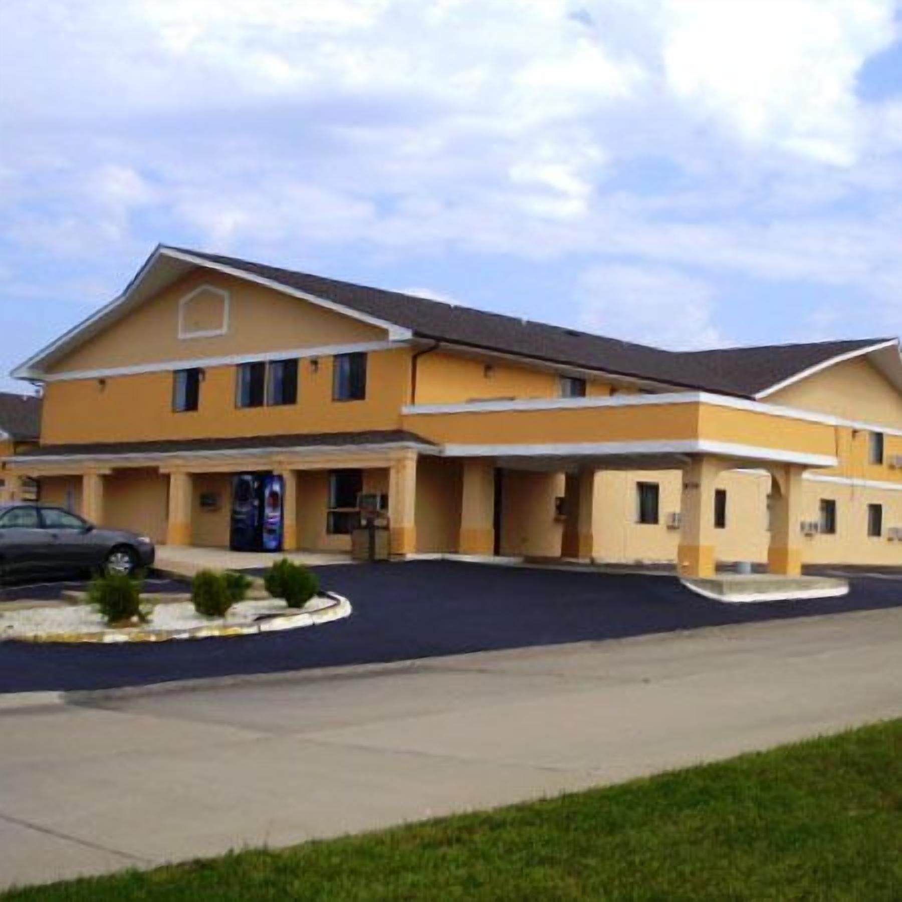 A two-story motel with a flat roof and a parking lot.
