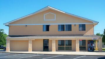 A two-story building with a flat roof, a central entrance, and a sign indicating it is an Economy Inn Office.