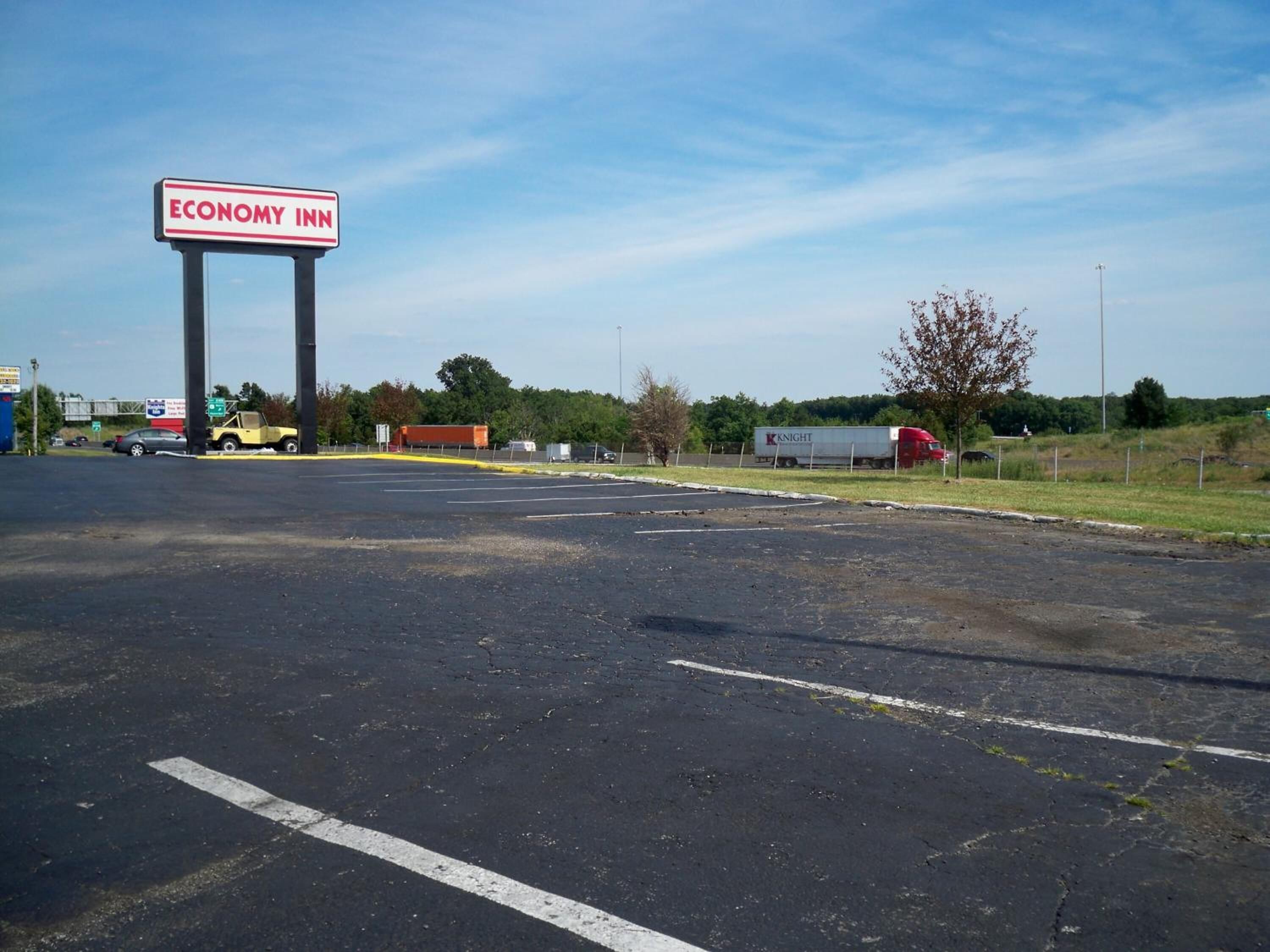 Un parking avec un panneau indiquant l’établissement « Economy Inn ».