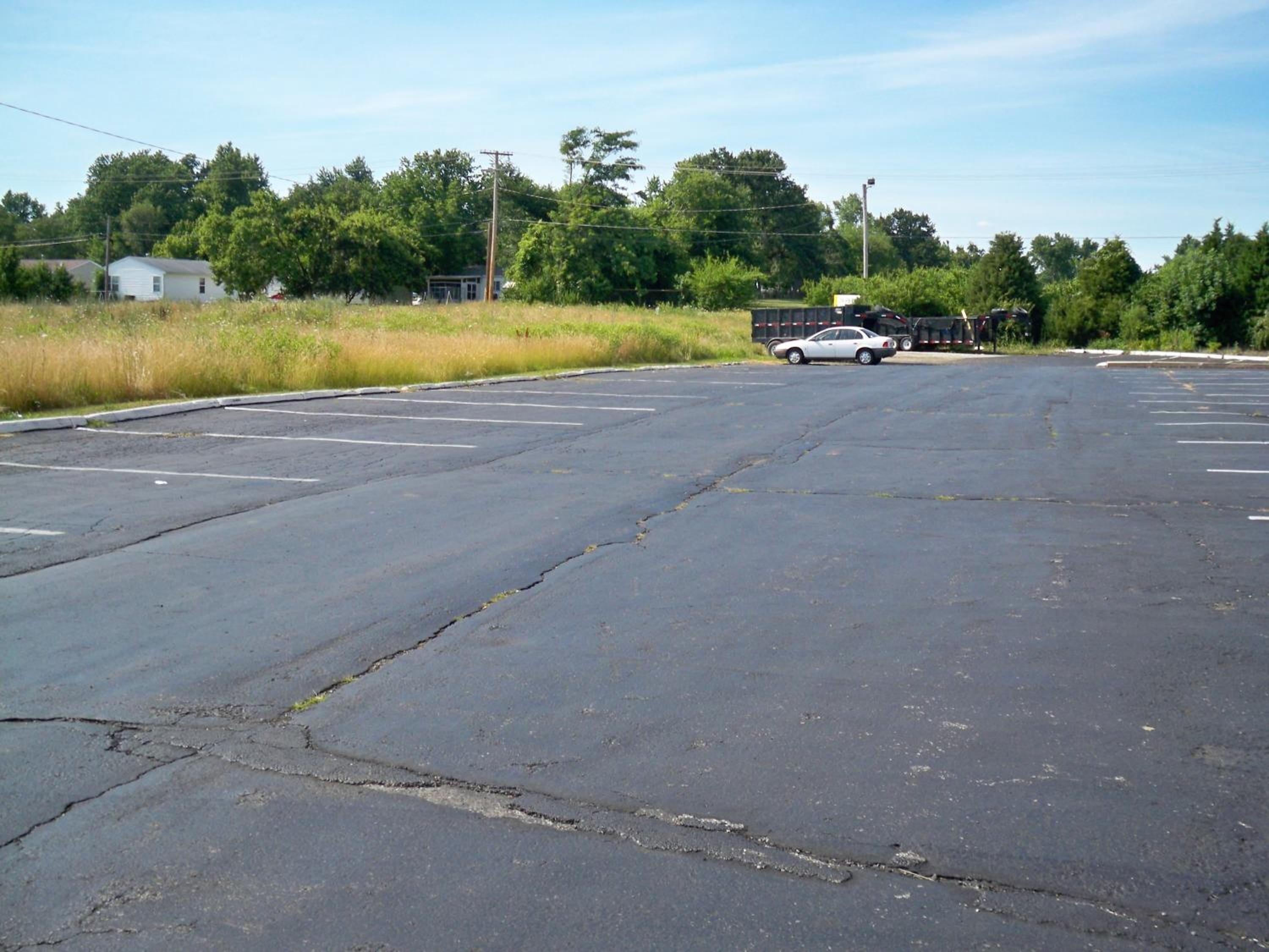 A parking lot with a white car and a truck.