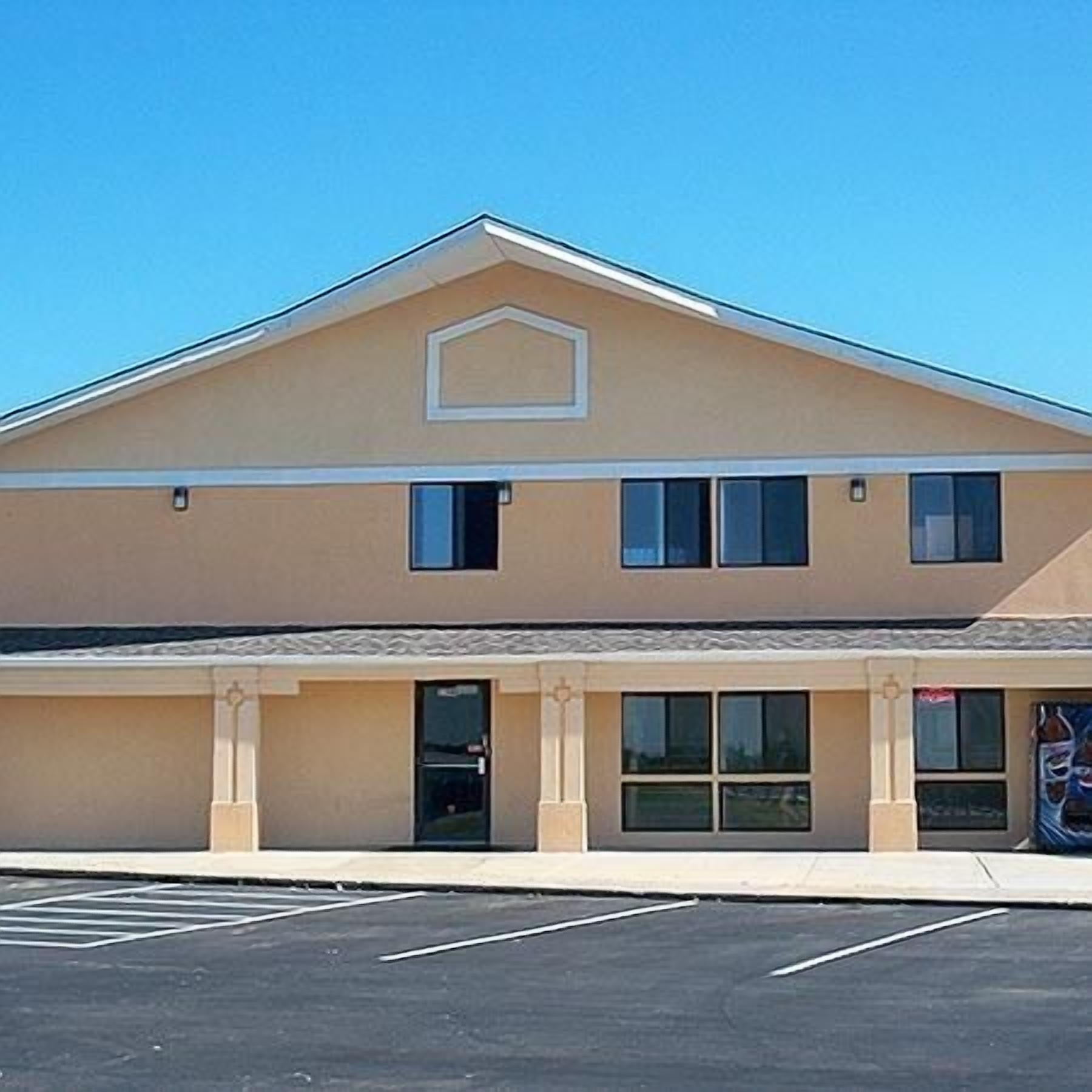 A two-story building with a flat roof and a central entrance.