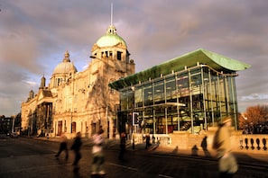 A historic building with a large dome and a modern glass extension.