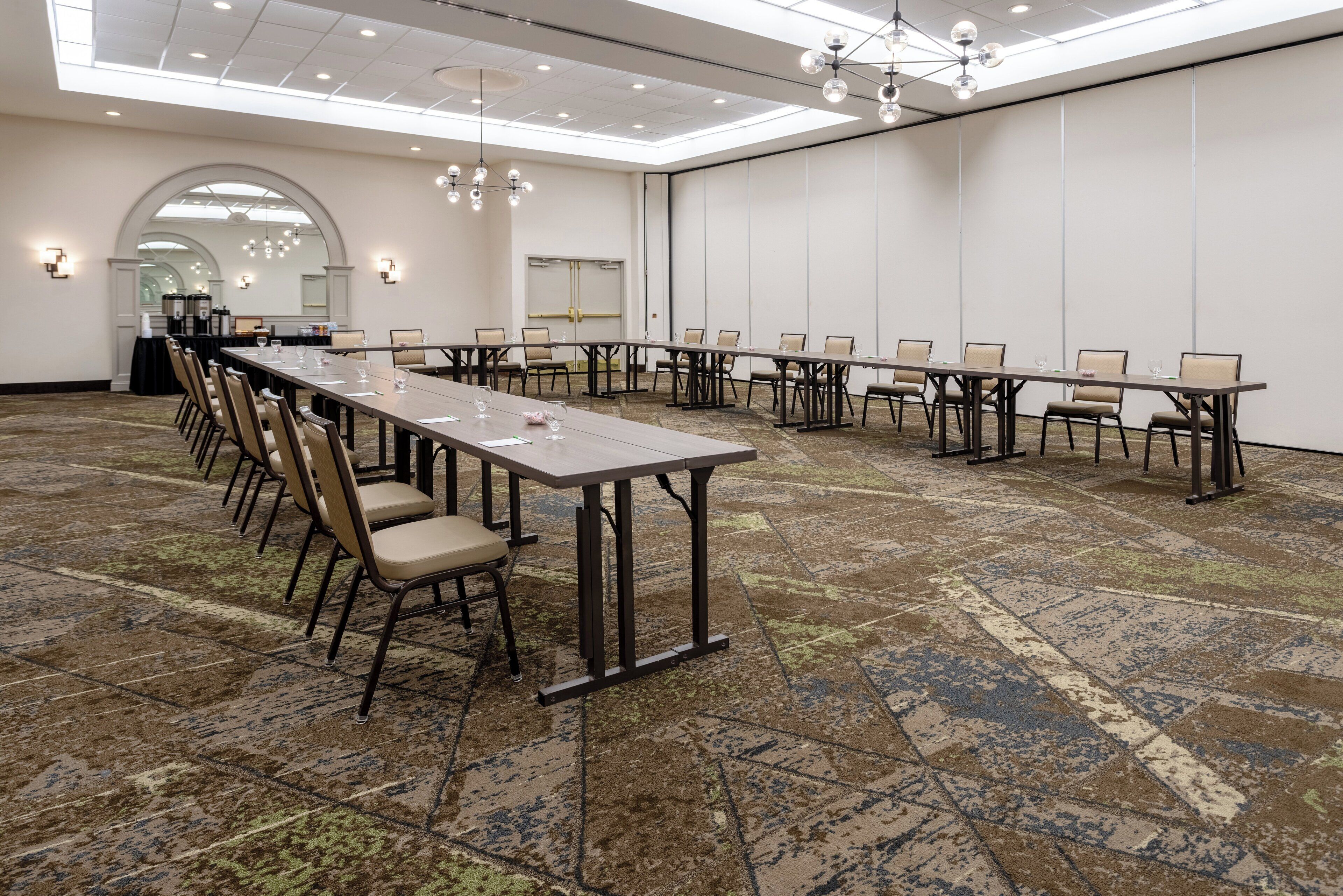 A conference room with a long table, multiple chairs, and a carpeted floor.