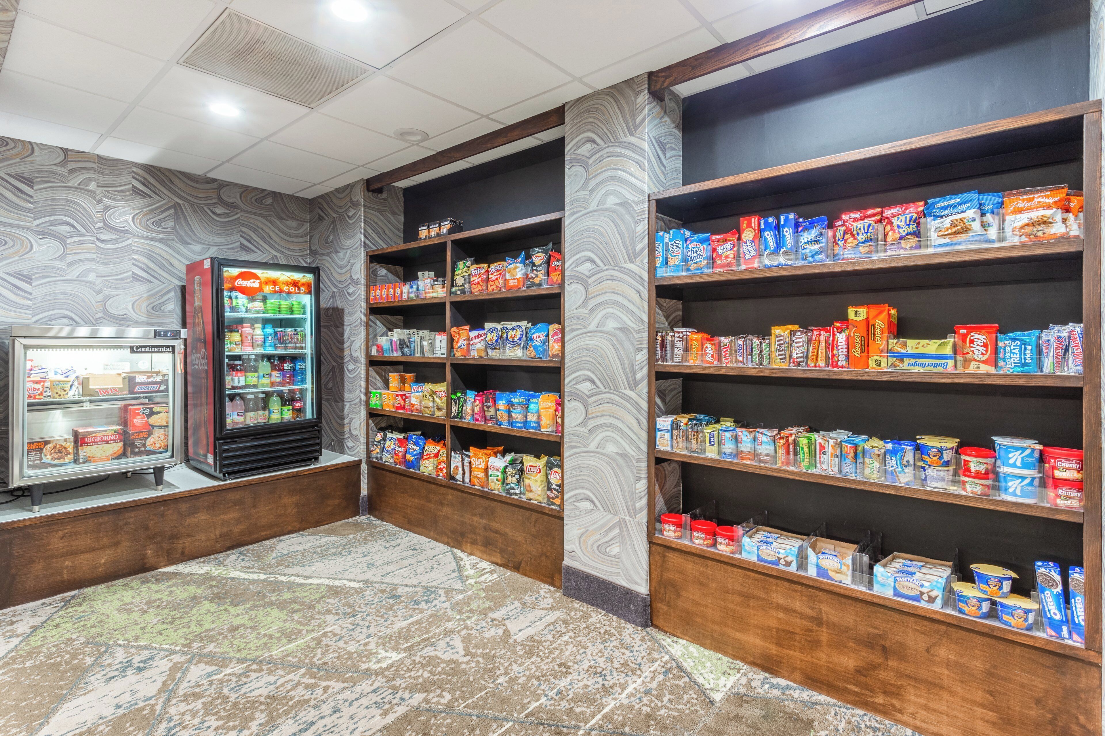 A snack and beverage vending area with shelves stocked with various snacks and drinks.