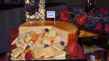 A dessert display with a cheesecake topped with fruit and a sign indicating 'applewood cheddar'.