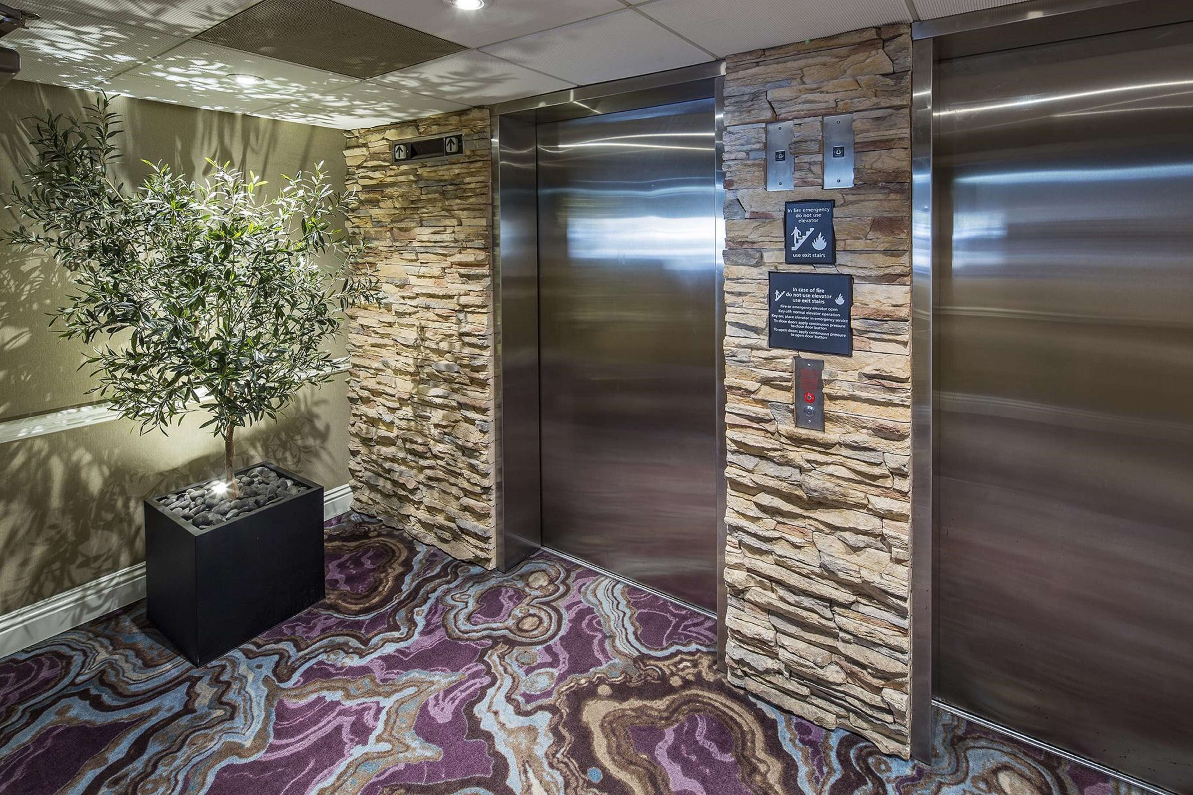 An elevator with stone walls and a marble-patterned floor.