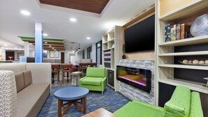Un espace de détente moderne avec un canapé, un fauteuil vert et une petite table.