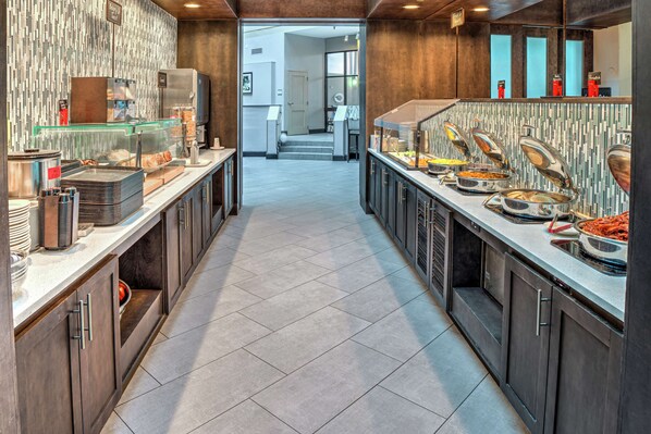 A modern kitchen with a long counter, glass display cases, and a variety of food items.