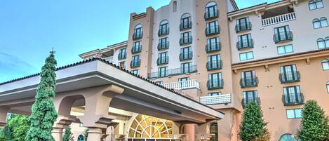 A multi-story hotel with a central entrance featuring a large arched doorway.