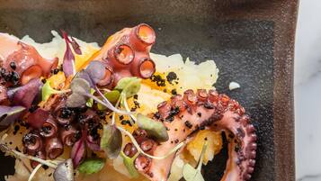 Un plato de pulpo y diversas guarniciones.