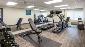 A gym with treadmills, elliptical machines, and weight benches.