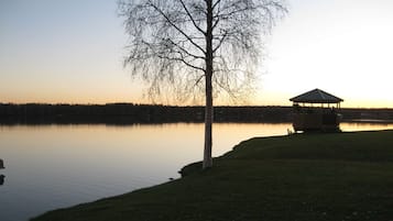 Un pabellón junto a un lago tranquilo al atardecer.