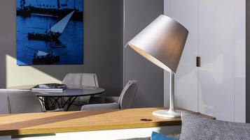 Une chambre moderne équipée d’un bureau, d’une chaise, d’une table, d’une lampe et d’un tableau au mur.