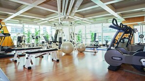Een sportschool met cardioapparatuur, gewichthefmaterialen en fitnessballen.