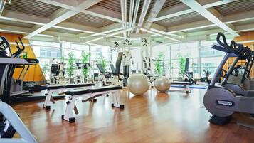 Une salle de sport équipée de machines de cardio, de matériel de musculation et de ballons d’exercice.
