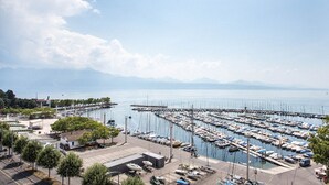Un puerto deportivo con numerosos barcos amarrados, un muelle que se adentra en el agua y un cielo despejado.