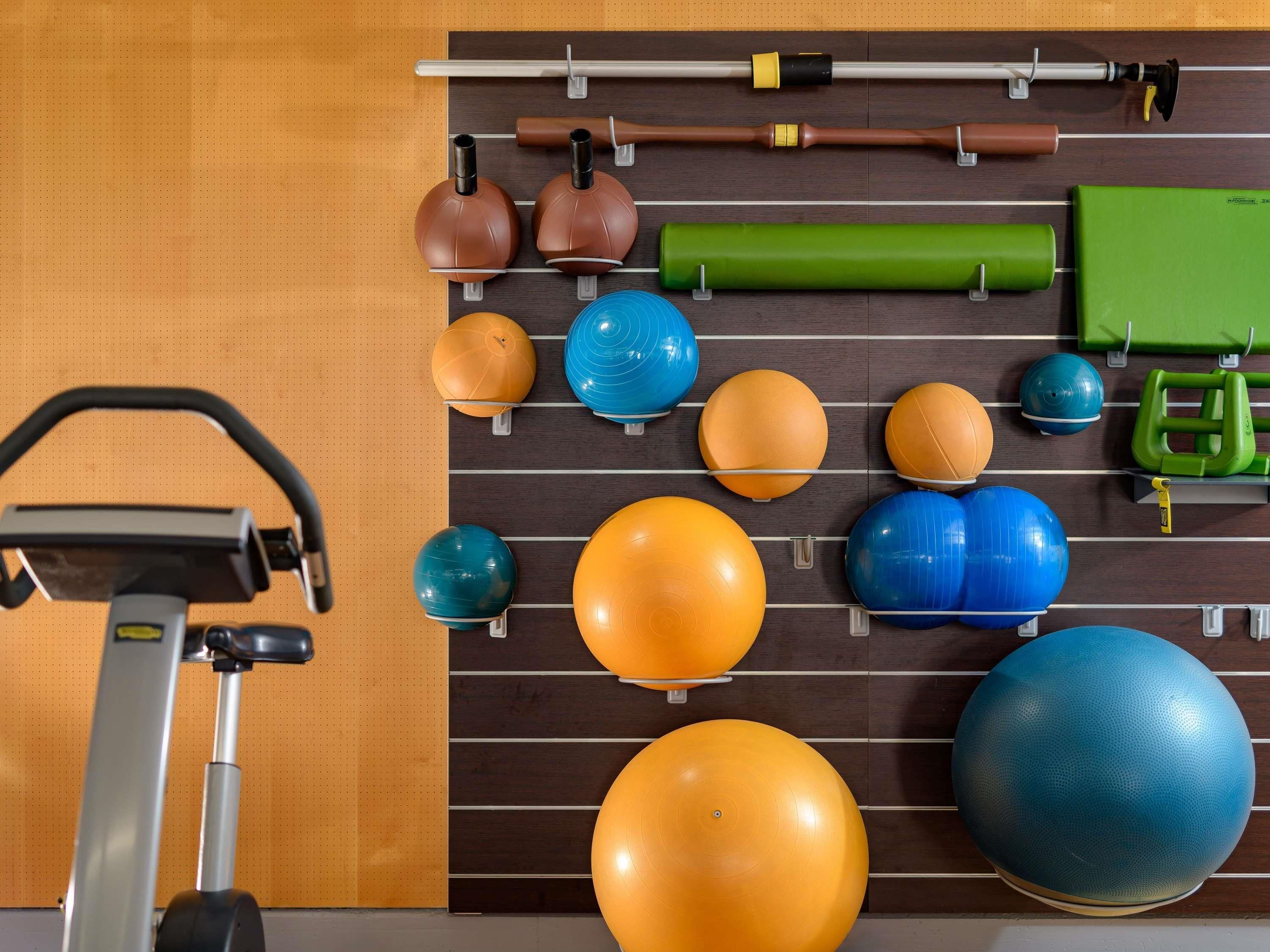 A gym with exercise equipment, including kettlebells, medicine balls, and a stationary bike.