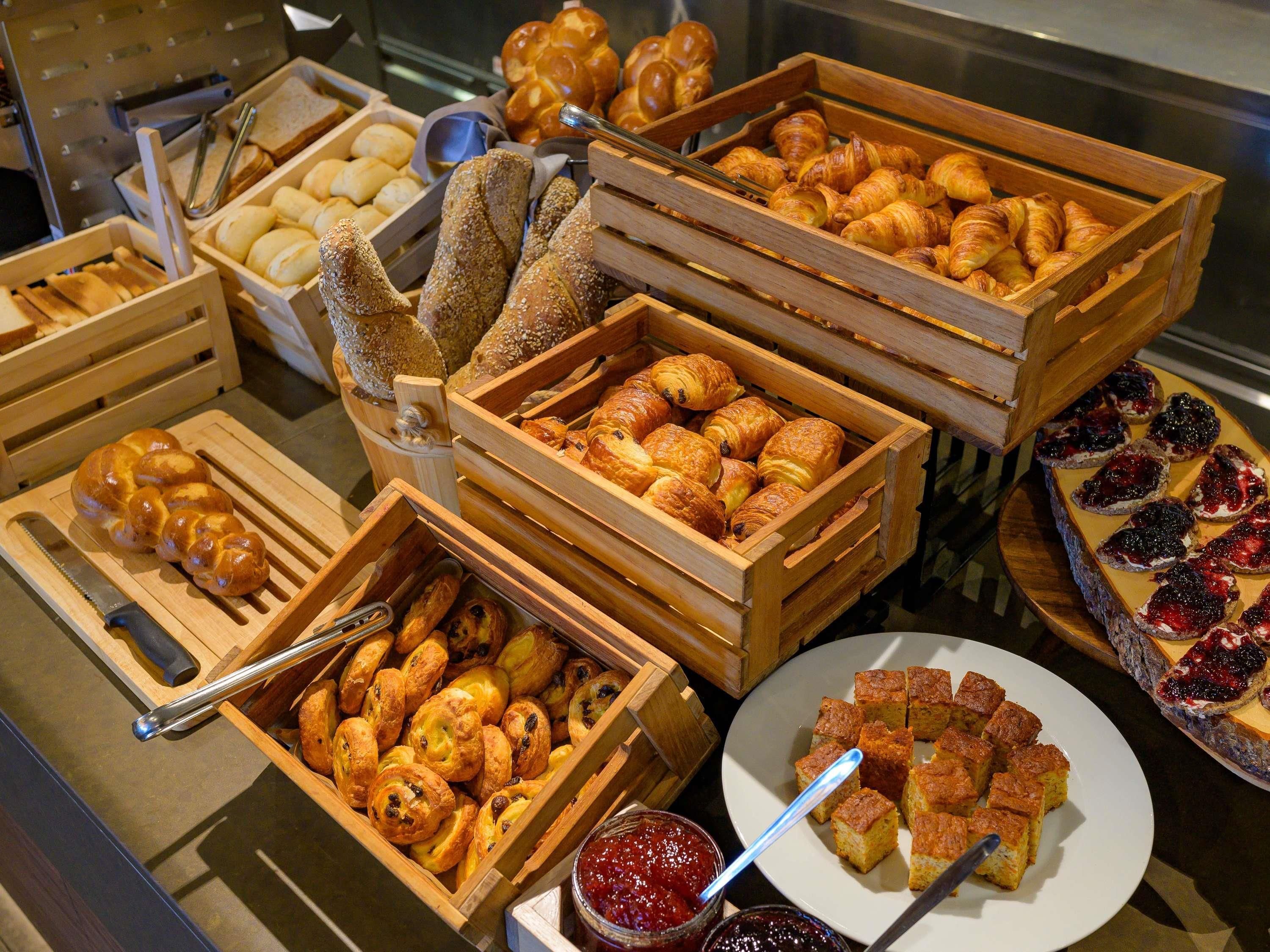 Une variété de produits de boulangerie présentés dans des caisses en bois.