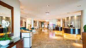 Un hall amplio con mostrador de recepción, zona de estar y diseño moderno.