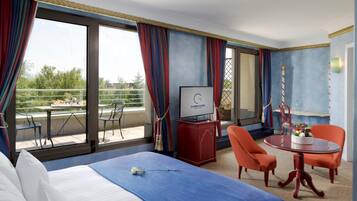 A hotel room with a bed, a desk, a chair, a table, and a view of the outdoors.