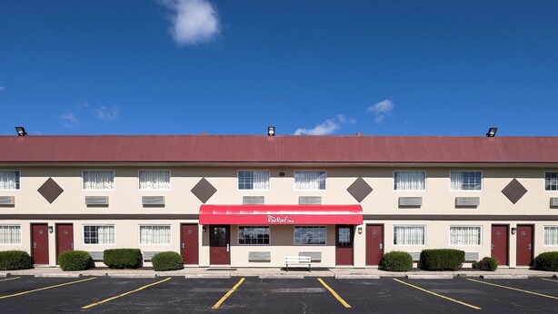 A Red Roof Inn with a red awning, multiple windows, and a parking lot. - Red Roof Inn Dayton - Huber Heights (Dayton)
